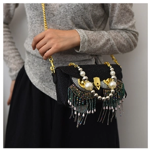 Detail of owl-shaped evening bag with black rhinestones and beaded fringe tassels