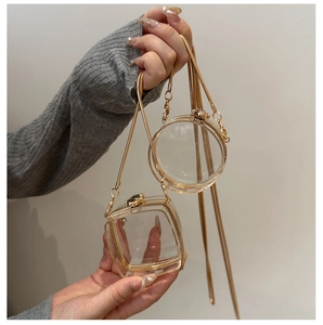 Detailed view of clear acrylic mini crossbody bags with gold snake chains and metal clasps