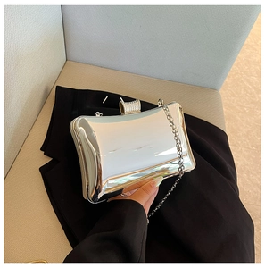 Detailansicht der silbernen Spiegel-Clutch mit Strassverschluss und eleganter Metallkette