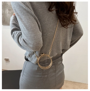 Mini acrylic round clear jelly bag with golden chain strap shown on model back