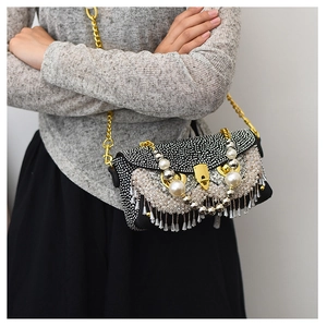 Detail of owl-style chain bag with rhinestones, pearls, and crystal fringe tassels