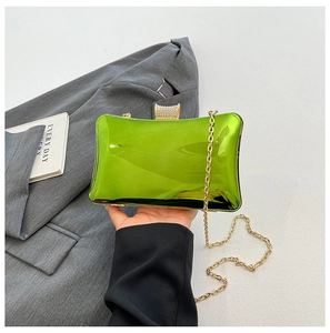 Detail der lindgrünen Spiegel-Clutch mit goldener Kette und Diamantverschluss