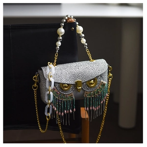 Macro shot of owl-shaped party clutch featuring crystal rhinestones and colorful tassels