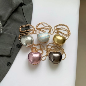 Mini heart-shaped crossbody bags in metallic colors with gold bead chains on a white background