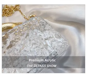 Detail of luxury acrylic evening bag with ice-crack texture and gold metal chain handle