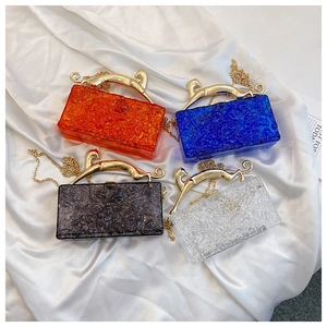 Detail view of acrylic box clutches featuring ice crackle texture and golden leopard handles