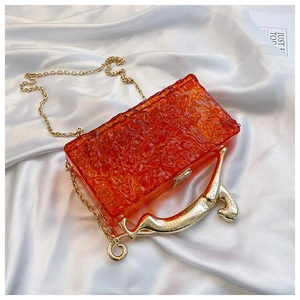 Detail of orange acrylic bag with ice-crack texture and golden leopard metal handle