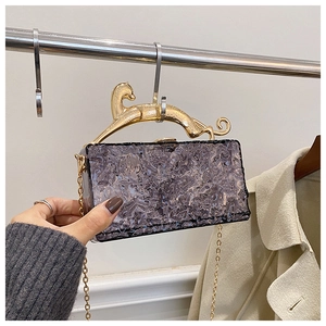 Detail of purple acrylic evening bag with wave texture and leopard handle gold chain