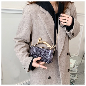 Detailed shot of purple acrylic clutch featuring a golden leopard handle and ice crack texture