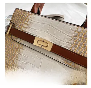 Detail of stone pattern texture and golden metal clasp on white and brown tote bag