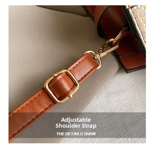 Close-up of adjustable brown leather shoulder strap with premium gold metal buckle