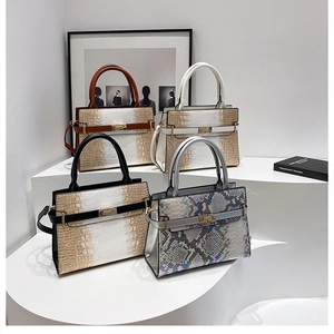 Detail of four faux leather tote bags with crocodile and snake textures and metal locks