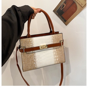 Detail of stone pattern tote with gold turn-lock closure and detachable strap