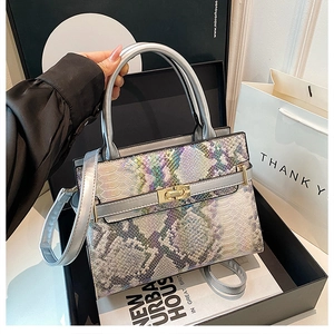 Detail of iridescent snakeskin pattern tote with silver metal handles and gold turn-lock
