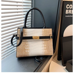 Detail of gradient crocodile embossed texture and golden metal buckle on tote bag