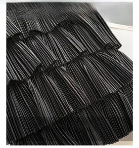 Close-up of the pleated black fabric texture on this layered cake-style tote bag