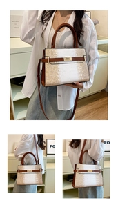 Detail of a color-block faux crocodile leather handbag with gold buckle and adjustable strap