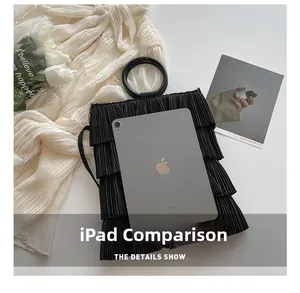 Detailed view of black pleated tiered bucket bag compared with an iPad for size reference