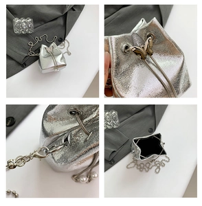 Details einer Mini-Eimertasche in Silber mit goldenem Schmetterling und Perlen