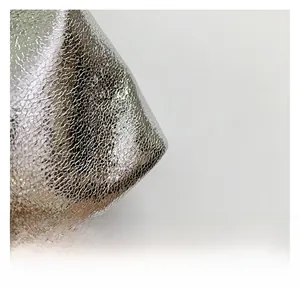 Detail aus silbernem Metallic-Gewebe mit Glitzerbeschichtung für Beuteltasche