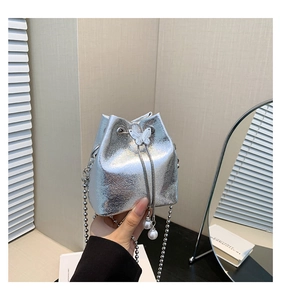 Detail der silbernen Beuteltasche mit Schmetterlingsschnalle und Perlen-Kordelzug-Effekt