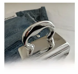 Detail view of mirror silver acrylic box bag with unique curved metal handle and chain