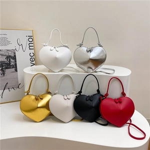 Chic 3D heart-shaped crossbody bags in multi-color options on a minimalist display stand