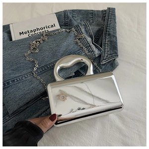 Silver mirror acrylic box bag featuring unique fluid handle and sleek metal chain strap