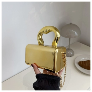 Close-up of golden mirror acrylic handbag with a chunky handle and gold chain strap