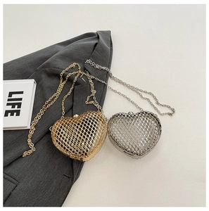 Close-up of heart-shaped woven metal mesh chain bags in gold and silver finishes