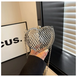 Detailed view of heart-shaped silver hollow out metal clutch bag with chain strap