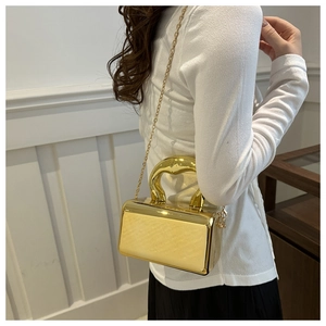 Glossy gold acrylic box bag with metal handle and detachable chain strap detail