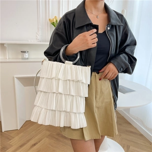 White tiered ruffle bucket bag with transparent round handle shown in a lifestyle setting