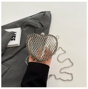 Detail shot of heart-shaped silver metal mesh clutch bag with delicate chain strap