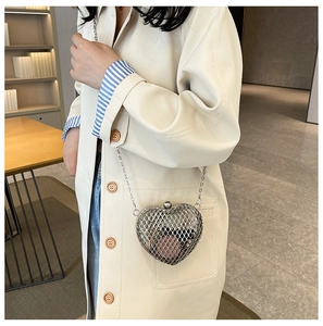 Detail of silver heart-shaped metal hollow mesh bag with spherical clasp and chain strap