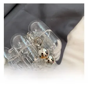 Detail of clear wave acrylic bag featuring silver metal beads and spring snap hook clasp