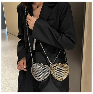 Macro detail of heart-shaped hollow metal evening bag with gold and silver woven textures