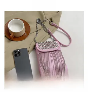 Detailed shot of pink crossbody bag featuring silver studs and metallic tassel decoration