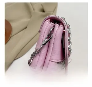 Detailed close-up of pink litchi PU leather bag with rhinestones and silver chain