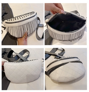 Detail view of white quilted waist bag featuring silver studs and metal chain fringe