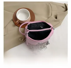 Pink leather shoulder bag detail with silver metal fringes and dual zipper compartments