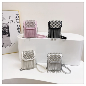 Detail of four studded tassel crossbody bags in pink, black, white, and silver colors