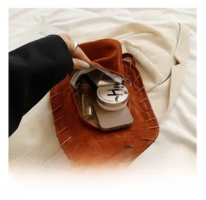 Detail view of caramel suede hat-shaped backpack showing interior storage capacity
