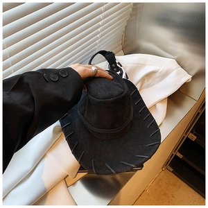 Close-up of black wool fedora featuring woven brim edges and stylish zipper detail