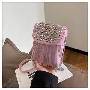 Detailed view of pink crossbody bag with silver rhinestone studs and metal chain fringe