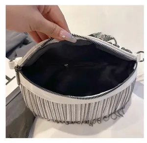 Detail view of white fringe bag interior showing the zipper pocket and ample storage