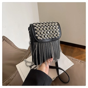 Detail of black crossbody bag featuring silver rhinestone studs and long metal chain tassels