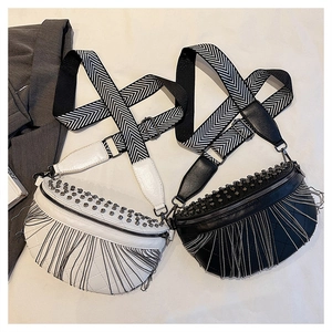 Detail of studded leather fanny packs with metal tassel chains and patterned wide straps