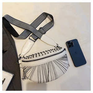 Detail of white moon tassel bag with rivets, quilted pattern and woven wide strap