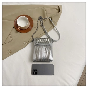 Silver metallic crossbody bag with sparkling rhinestones and fringes shown next to phone